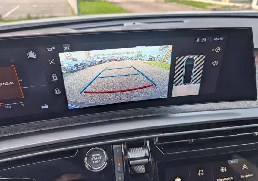 Écran central du Peugeot 3008 blanc 2025 montrant la caméra de recul et l'affichage de stationnement assisté.