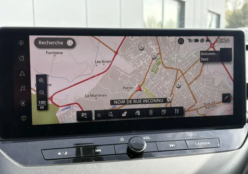 Écran tactile GPS du Nissan Juke 2025 affichant une carte avec options de zoom et menu en bas.