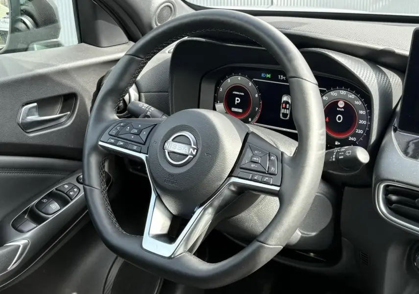 Vue rapprochée du volant noir et du tableau de bord numérique du Nissan Juke 2025 côté conducteur.