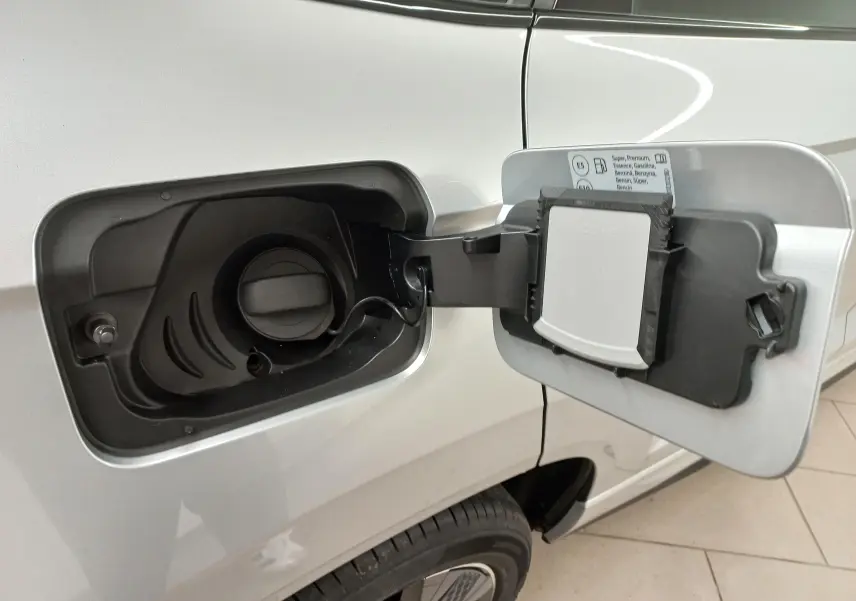 Gros plan sur la trappe à carburant ouverte côté gauche d’un Skoda Karoq gris argent 2025.