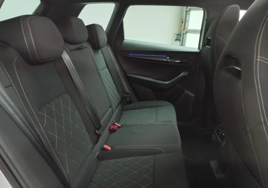 Vue intérieure côté droit des sièges arrière noirs avec surpiqûres blanches du Skoda Karoq 2025 Sportline.