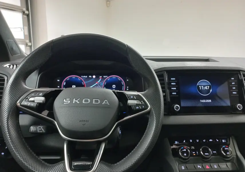 Vue intérieure centrée sur le volant SKODA et le tableau de bord numérique du Karoq gris argent 2025 Sportline.