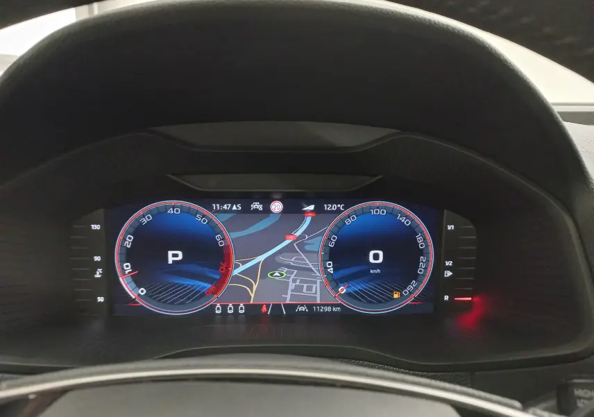 Vue rapprochée du tableau de bord numérique du Skoda Karoq gris argent 2025, affichant la navigation et les compteurs.