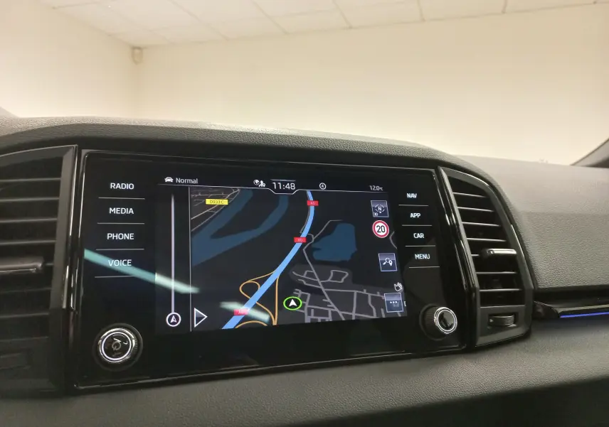Écran tactile central du tableau de bord du Skoda Karoq gris argent, affichant la navigation GPS en intérieur.