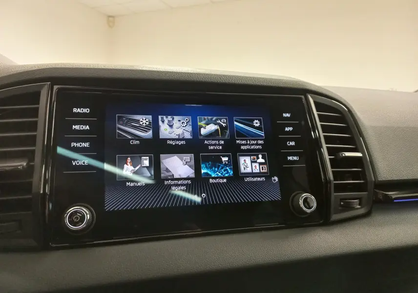 Écran tactile central du tableau de bord du Skoda Karoq 2025, affichant le menu des réglages et services.