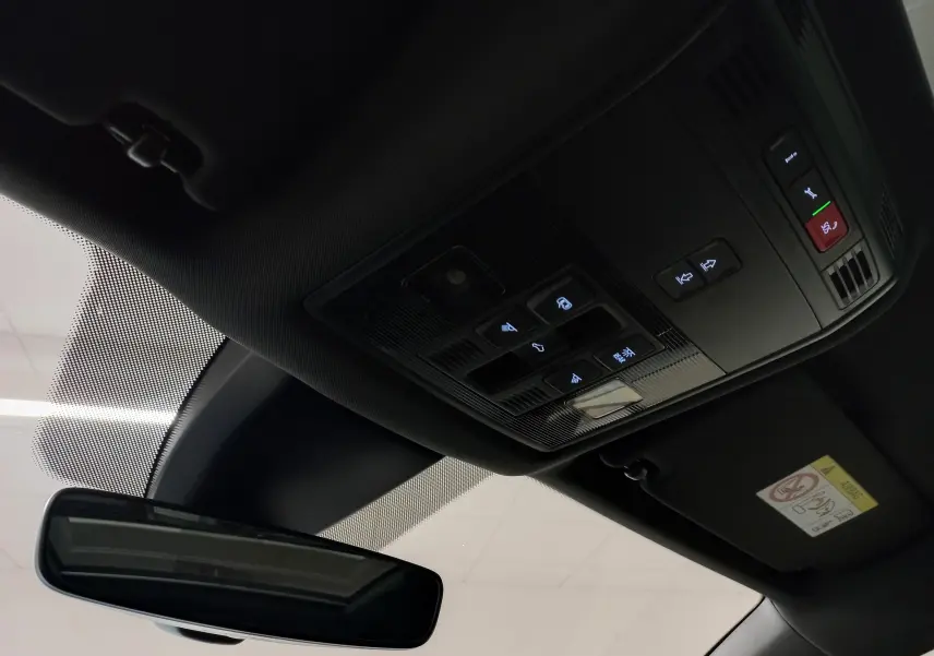 Vue intérieure du toit ouvrant panoramique et de la console de commandes au plafond du Skoda Karoq gris argent 2025.