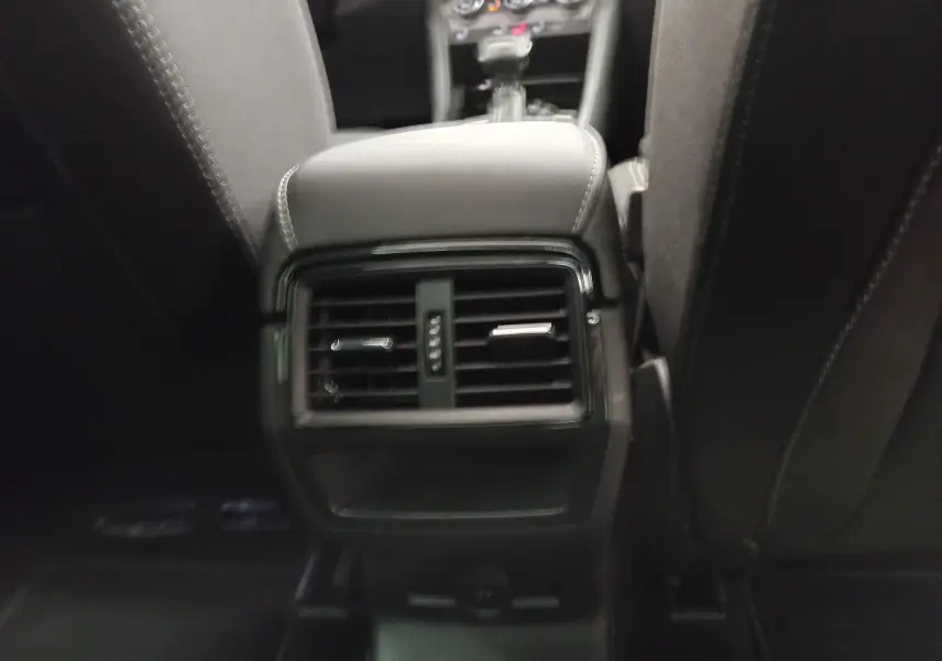 Vue rapprochée de la console centrale arrière du Skoda Karoq 2025, avec aérateurs noirs et sellerie sombre.