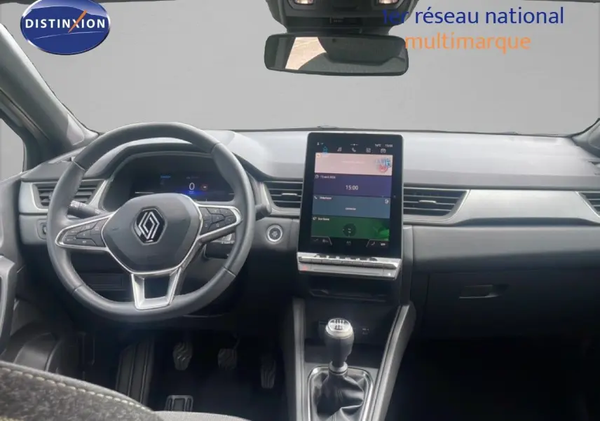Vue intérieure frontale du tableau de bord du Renault Captur 2025 avec volant multifonction et écran tactile vertical.