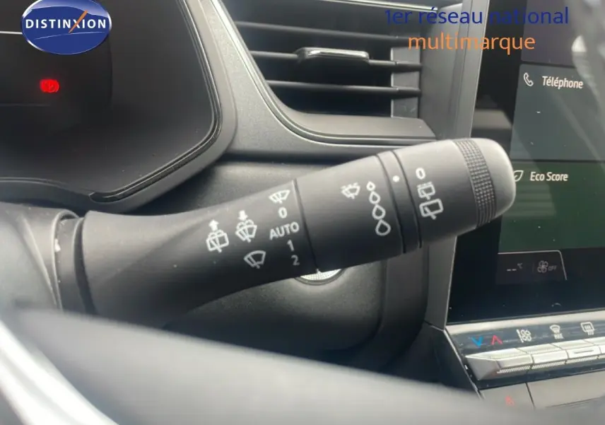 Gros plan sur la commande d'essuie-glace à gauche du volant dans l'habitacle du Renault Captur noir étoile métal avec toit gris.