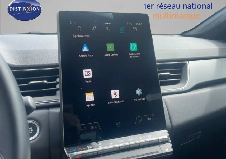 Vue intérieure centrée sur l'écran tactile vertical du tableau de bord du Renault Captur 2025, avec commandes climatisation visibles.