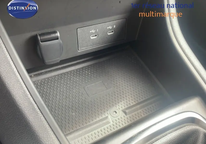 Gros plan sur la console centrale du Renault Captur 2025, montrant les ports USB et le tapis de rangement noir.