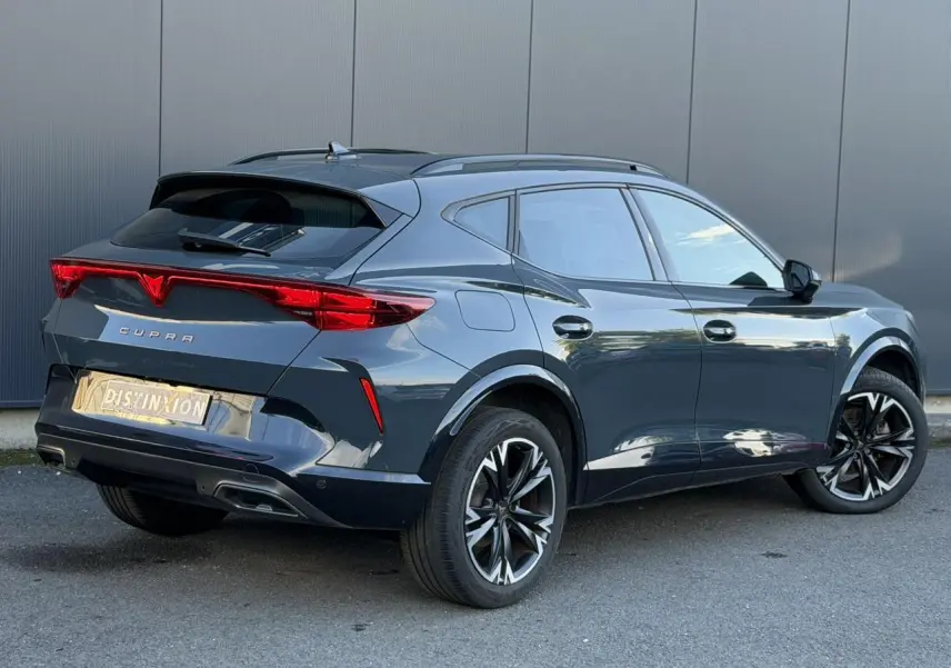 Vue 3/4 arrière droite du CUPRA Formentor bleu Fjord avec feux arrière Tri-LED et jantes alliage noires.