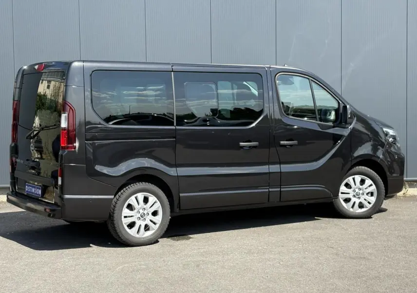 Vue latérale droite d'un Nissan Primastar Combi noir Minuit avec vitres arrière surteintées et jantes alliage 17 pouces.