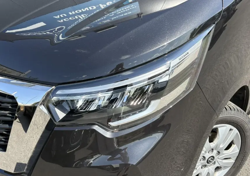 Gros plan sur le phare avant droit noir minuit du Nissan Primastar Combi 2025 avec jante alliage visible.