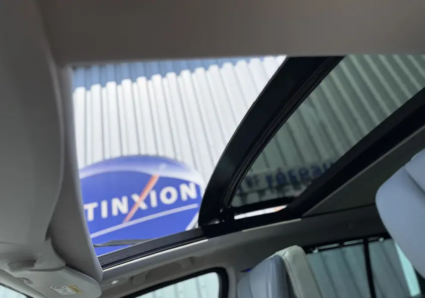 Vue intérieure du toit ouvrant panoramique du Renault Espace V noir, avec sièges en cuir gris visibles.