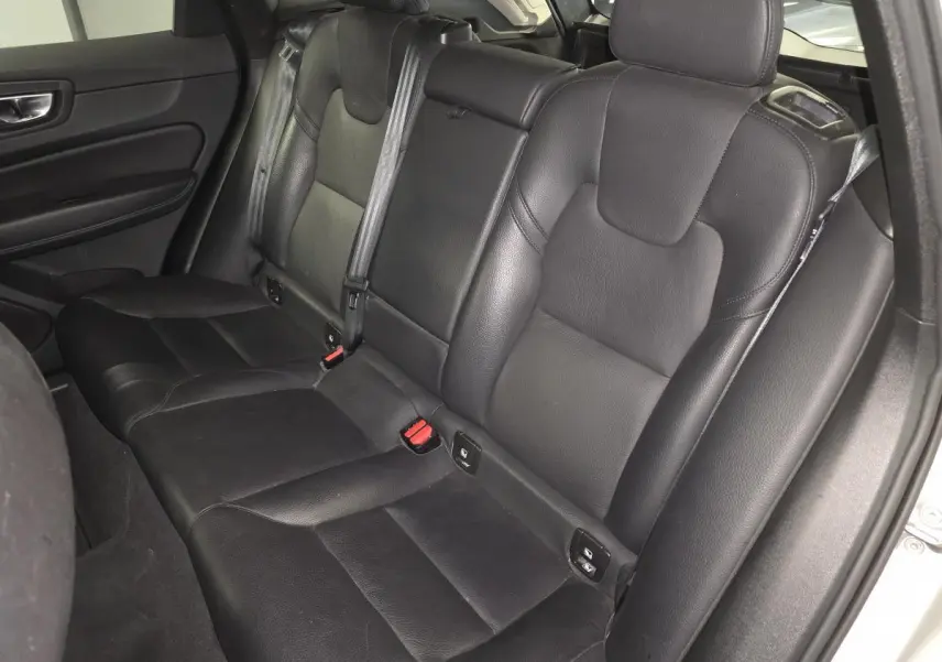 Vue intérieure du siège arrière en cuir noir du Volvo XC60 2023, côté droit avec ceintures de sécurité visibles.