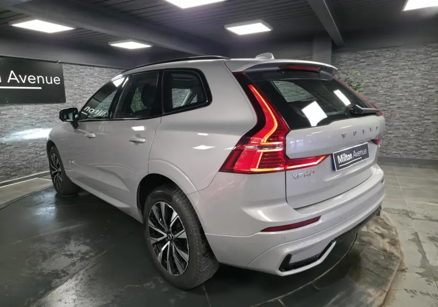 Vue 3/4 arrière droit du Volvo XC60 gris métallisé avec feux arrière LED en forme de L et jantes alliage noires.