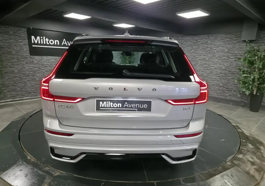 Vue arrière d'un Volvo XC60 gris métallisé avec feux LED en forme de C et double sortie d'échappement intégrée.
