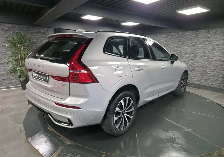 Vue 3/4 arrière droite d'un Volvo XC60 gris métallisé avec jantes alliage noires et inserts noir laqué.