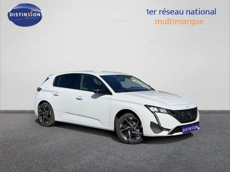 Peugeot 308 blanc Okénite vue 3/4 avant droit, jantes alliage noires et vitres arrière surteintées.