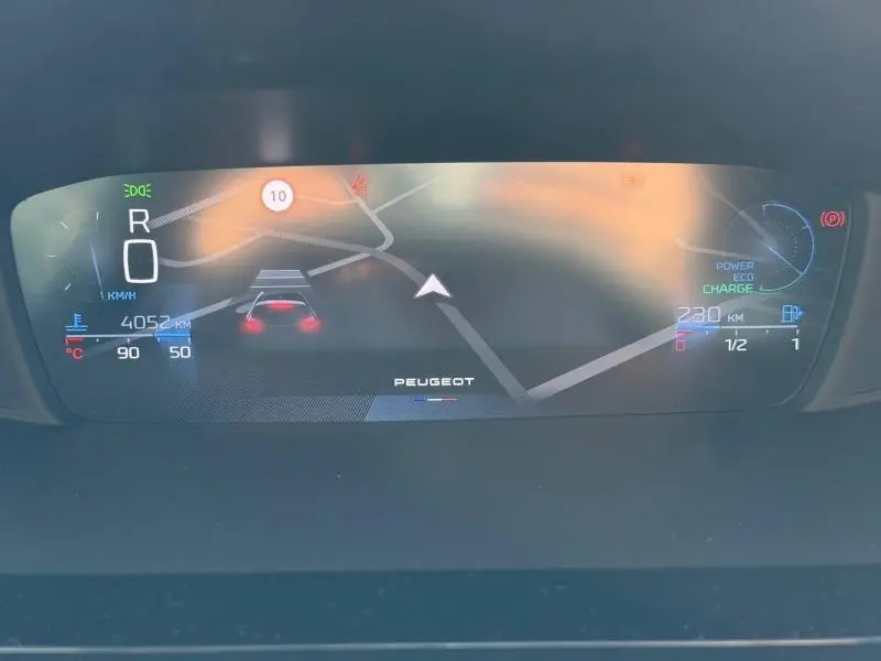 Affichage numérique du tableau de bord de la Peugeot 308 Hybrid, montrant la navigation et les indicateurs de vitesse et énergie.