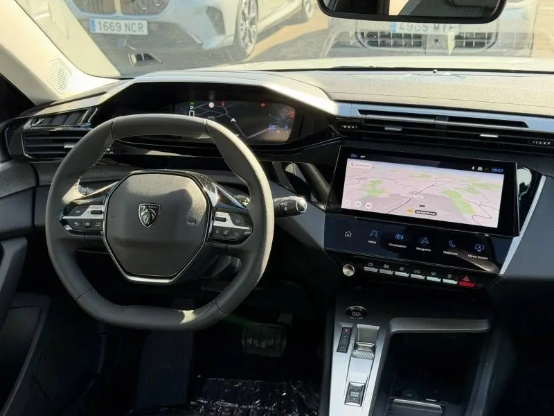 Vue intérieure avant du Peugeot 308 1.2 Hybrid avec tableau de bord numérique et écran tactile central affichant la navigation.