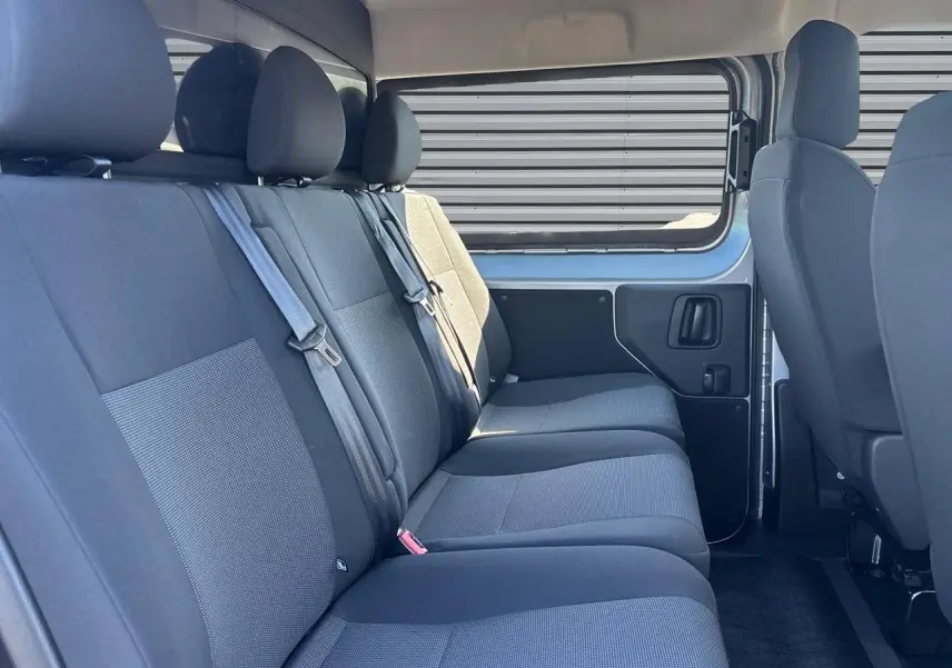 Vue intérieure côté droit sur la banquette arrière grise du Citroën Jumpy 2026 avec fenêtre latérale coulissante.