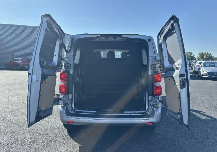 Vue arrière d'un Citroën Jumpy gris Artense avec portes battantes ouvertes montrant l'espace de chargement vide.