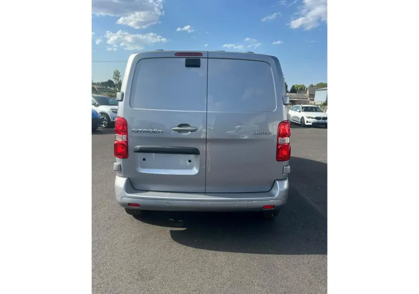 Vue arrière d'un Citroën Jumpy gris Artense avec portes battantes et caméra de recul visible en haut.