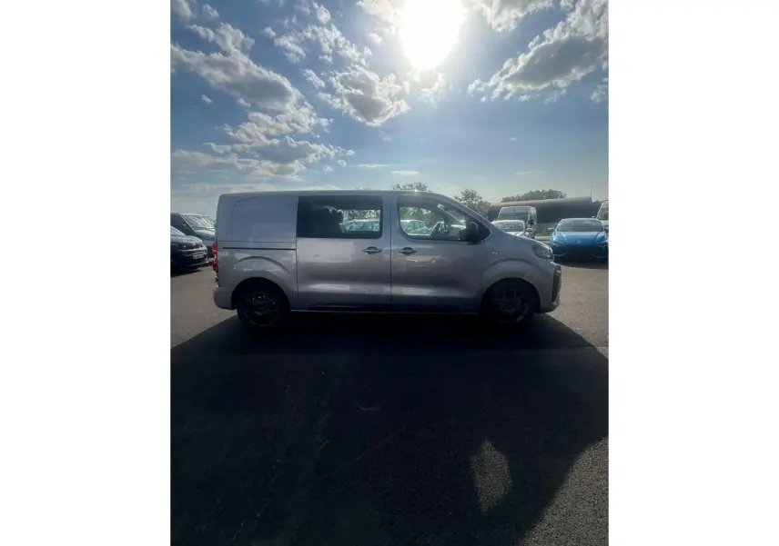 Vue de profil côté gauche d'un Citroën Jumpy gris Artense avec porte latérale coulissante et jantes noires.