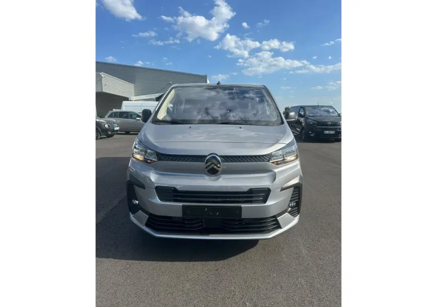 Vue avant d'un Citroën Jumpy gris Artense avec projecteurs antibrouillard et calandre noire sous un ciel bleu.