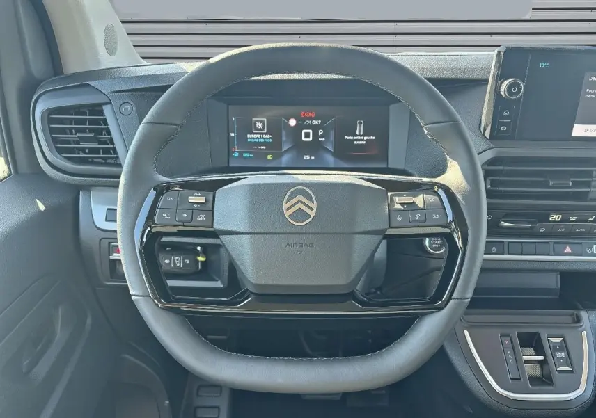 Vue intérieure centrée sur le volant en cuir noir du Citroën Jumpy 2026 avec tableau de bord digital et commandes intégrées.