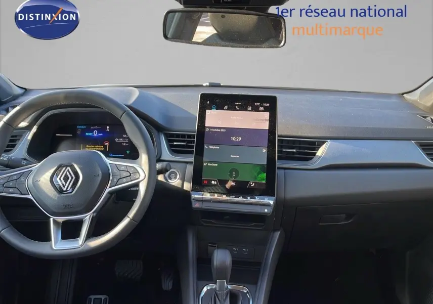 Intérieur du Renault Captur 2025 avec tableau de bord moderne, écran tactile vertical et volant multifonction noir.