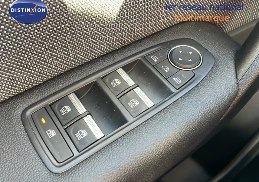 Boutons de commande des vitres et rétroviseurs sur la porte côté gauche d'un Renault Captur gris rafale métal toit noir.