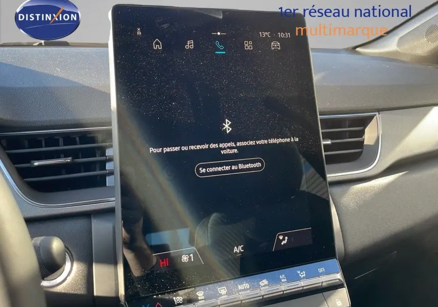 Vue intérieure du tableau de bord du Renault Captur 2025 avec écran tactile central et commandes climatisation visibles.