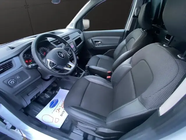 Intérieur côté conducteur du Renault Express Van blanc 2023, sièges tissu noir et tableau de bord avec écran tactile.