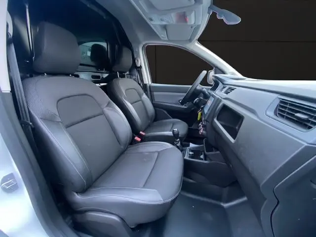 Intérieur avant du Renault Express Van 2023, sièges tissu noir, tableau de bord et levier de vitesse manuelle visibles côté conducteur.