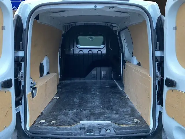Vue arrière intérieure du Renault Express Van blanc 2023 avec habillage bois et plancher noir antidérapant.