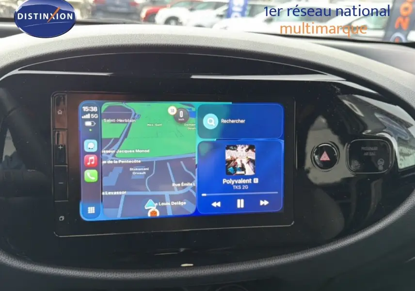 Écran tactile central de la Toyota Aygo X 2025 affichant navigation et musique, entouré de commandes noires brillantes.