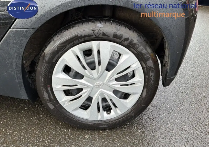 Gros plan sur la roue avant droite noire d’une Toyota Aygo X 2025 avec jante en alliage argentée et logo Toyota.
