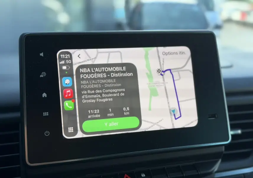 Écran tactile central affichant la navigation GPS dans l'habitacle du Nissan Primastar gris Comète, vue de face.