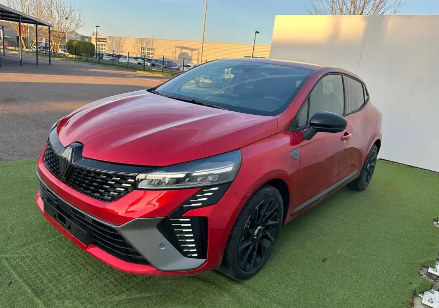 Renault Clio 2025 rouge foncé vue 3/4 avant droit avec calandre noire et jantes alliage noires.