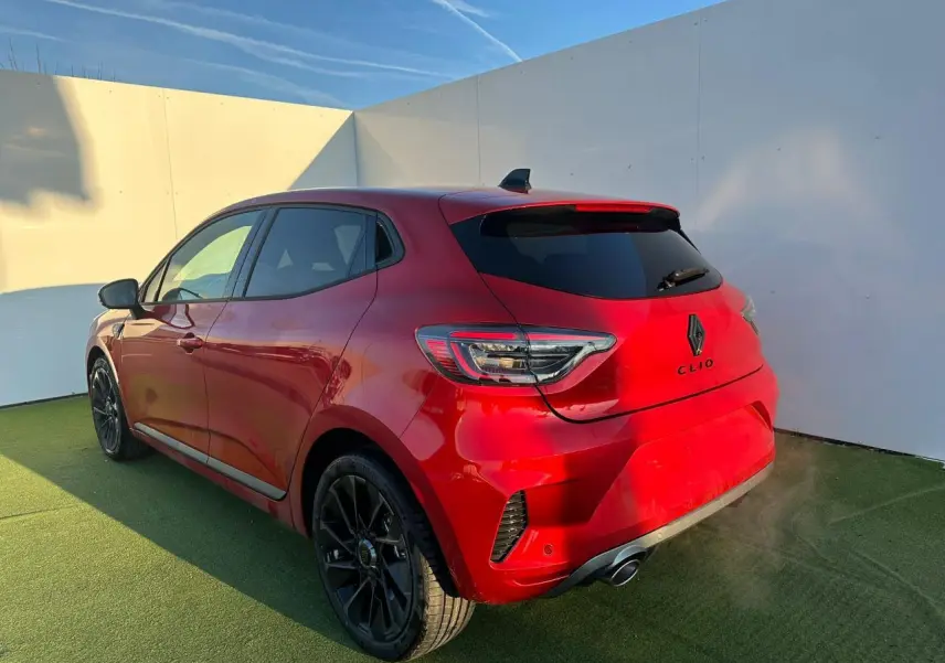Vue 3/4 arrière droite d'une Renault Clio rouge foncé avec jantes noires et badges Alpine sur fond clair.