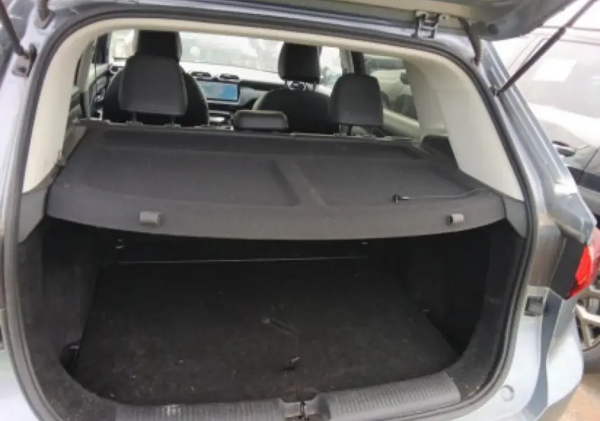 Coffre ouvert vu de l'arrière d'un MG MOTOR ZS 1.5 Hybrid+ 197 Luxury gris Hampstead avec banquette et tableau de bord visibles.