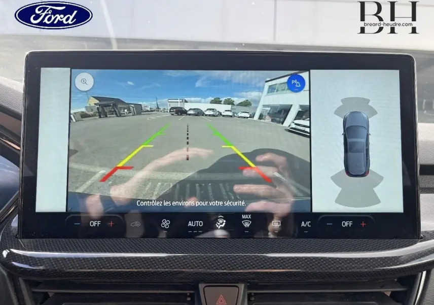 Écran tactile intérieur montrant la caméra de recul et l’aide au stationnement du Ford Focus SW bleu azur 2024.
