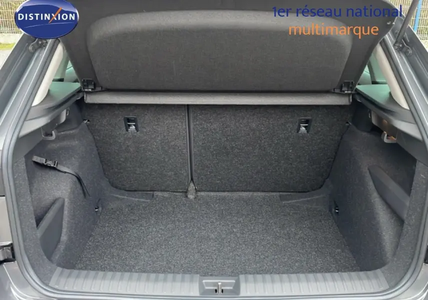 Coffre ouvert du Skoda Kamiq gris graphite métal, vue arrière montrant l'espace de chargement et la moquette intérieure.