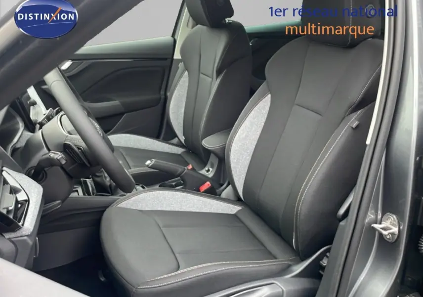 Intérieur du Skoda Kamiq 2025 montrant les sièges avant en tissu noir et gris avec surpiqûres blanches, côté conducteur ouvert.