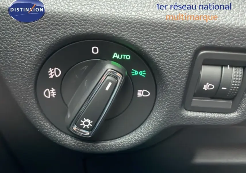 Gros plan sur la molette de réglage des phares du Skoda Kamiq gris graphite, avec fonction automatique activée.
