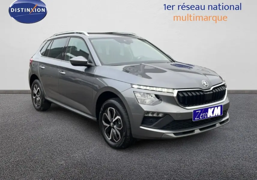 Vue 3/4 avant droit d'un Skoda Kamiq gris graphite métallisé avec calandre noire et jantes bi-ton.