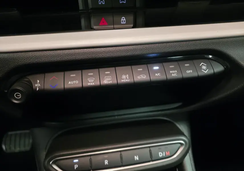 Vue rapprochée du tableau de bord de la FIAT 600 hybride 2024, montrant les commandes de climatisation et la boîte automatique.